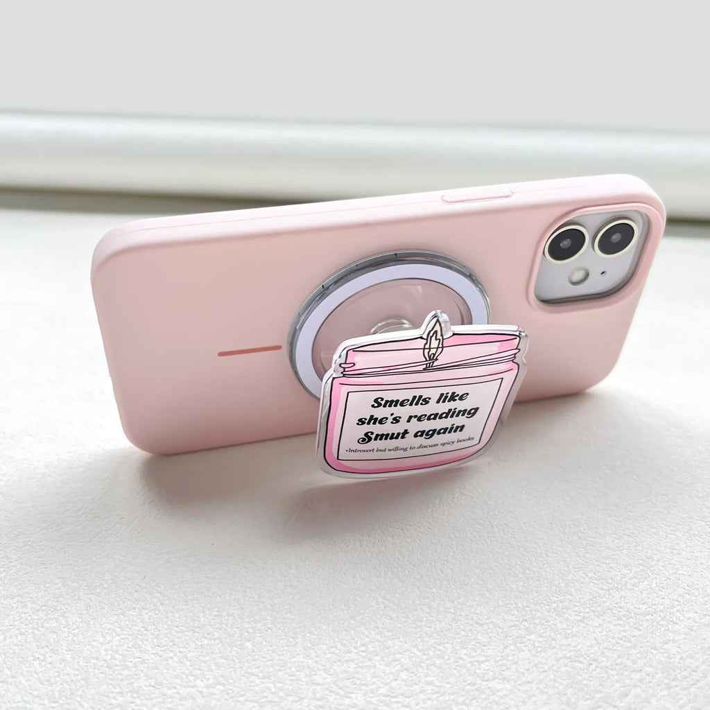 Side profile of a pastel pink smartphone with a pink candle-themed acrylic magnetic phone grip attached.