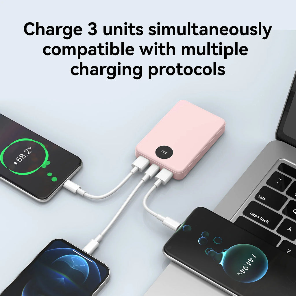 A pink portable power bank charging three smartphones simultaneously.