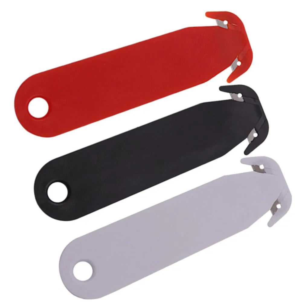 Three different colored double-edged plastic safety box cutters in red, black, and white stacked diagonally.