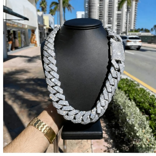 Silver-tone thick Cuban link chain with pave cubic zirconia stones on a black display bust