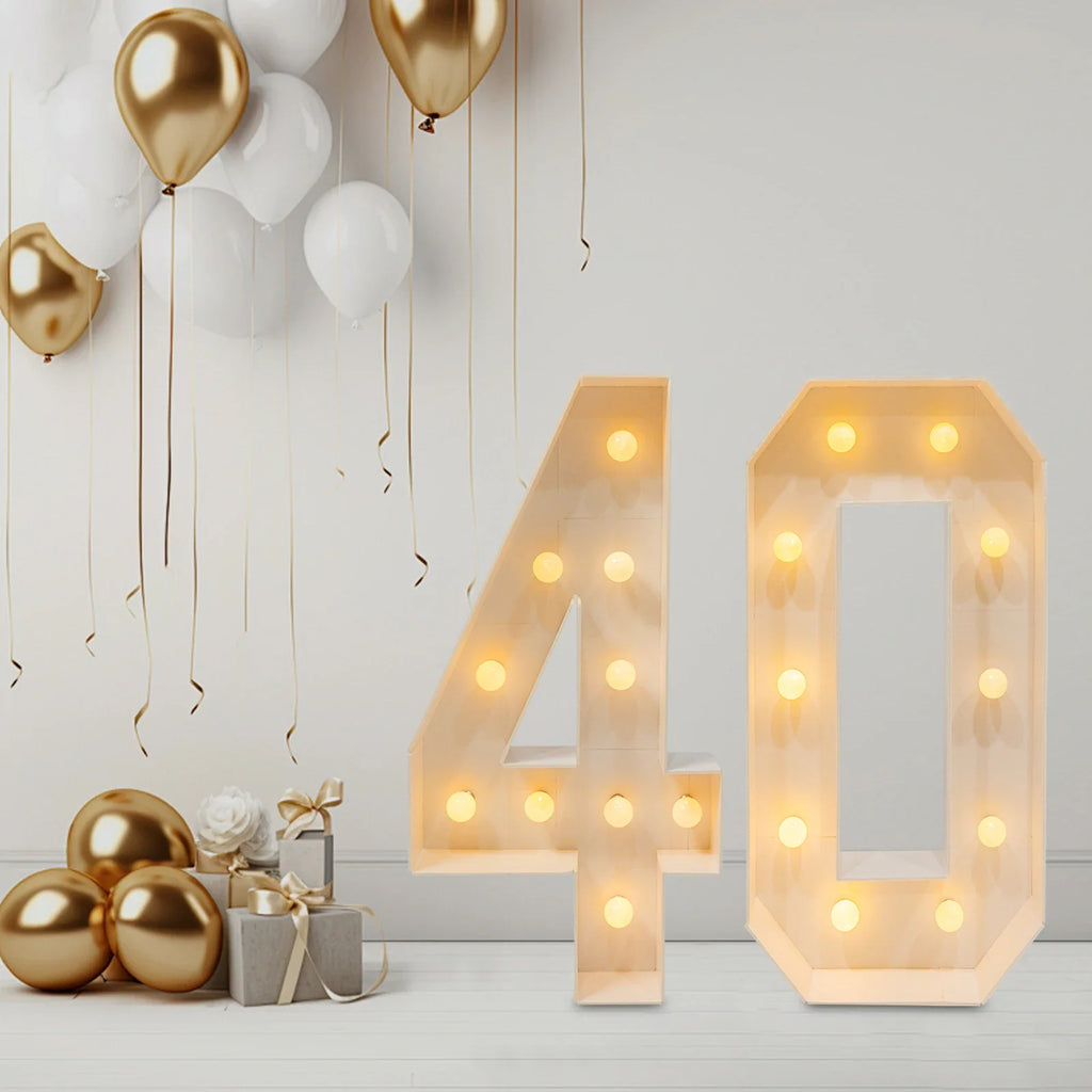 White light-up number 40 standing in a room with balloons and gift boxes