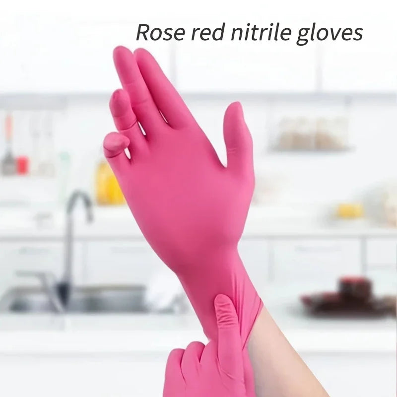 A close-up of hands wearing pink nitrile gloves in a kitchen setting