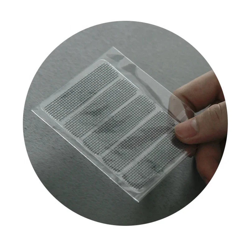 Hand holding a set of rectangular screen repair patches on a clear backing