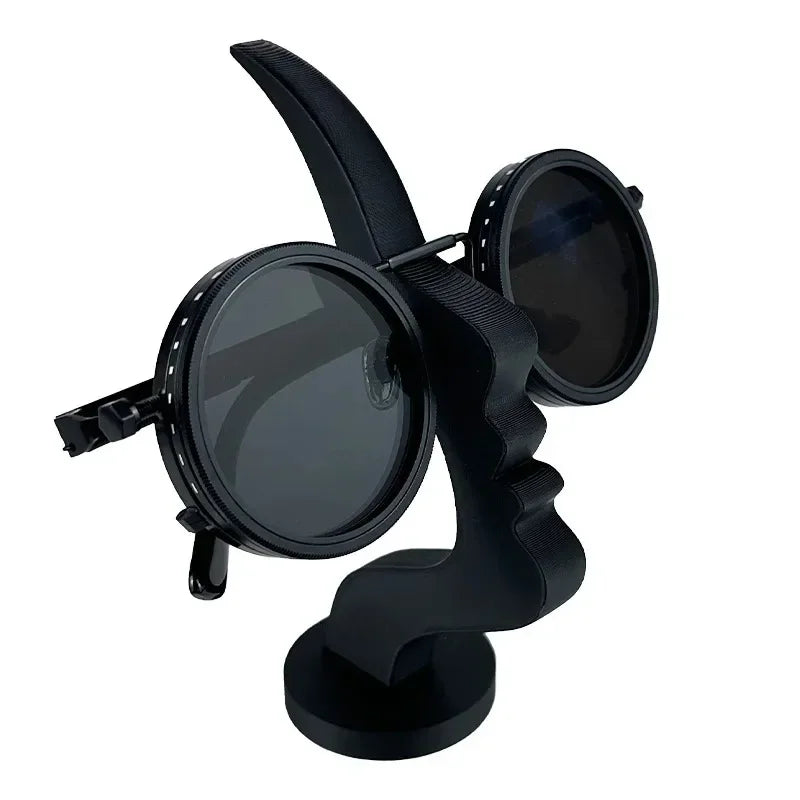 Black 3D-printed minimalist face-shaped eyeglass holder displaying circular sunglasses