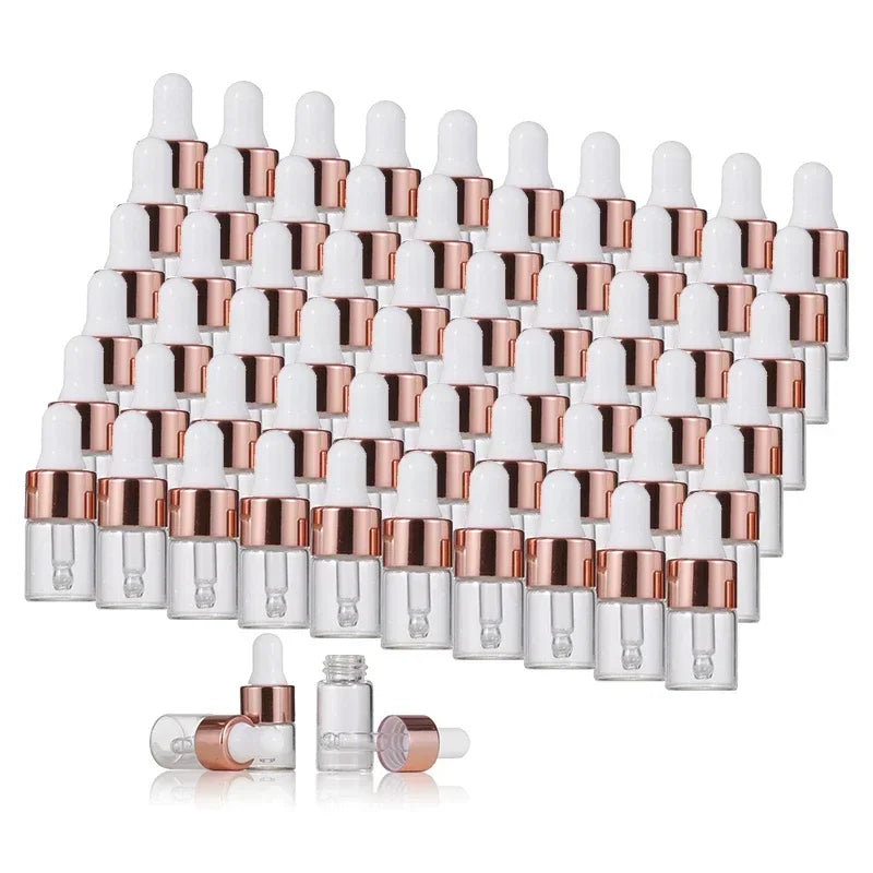A collection of small glass dropper bottles featuring rose gold caps for essential oils