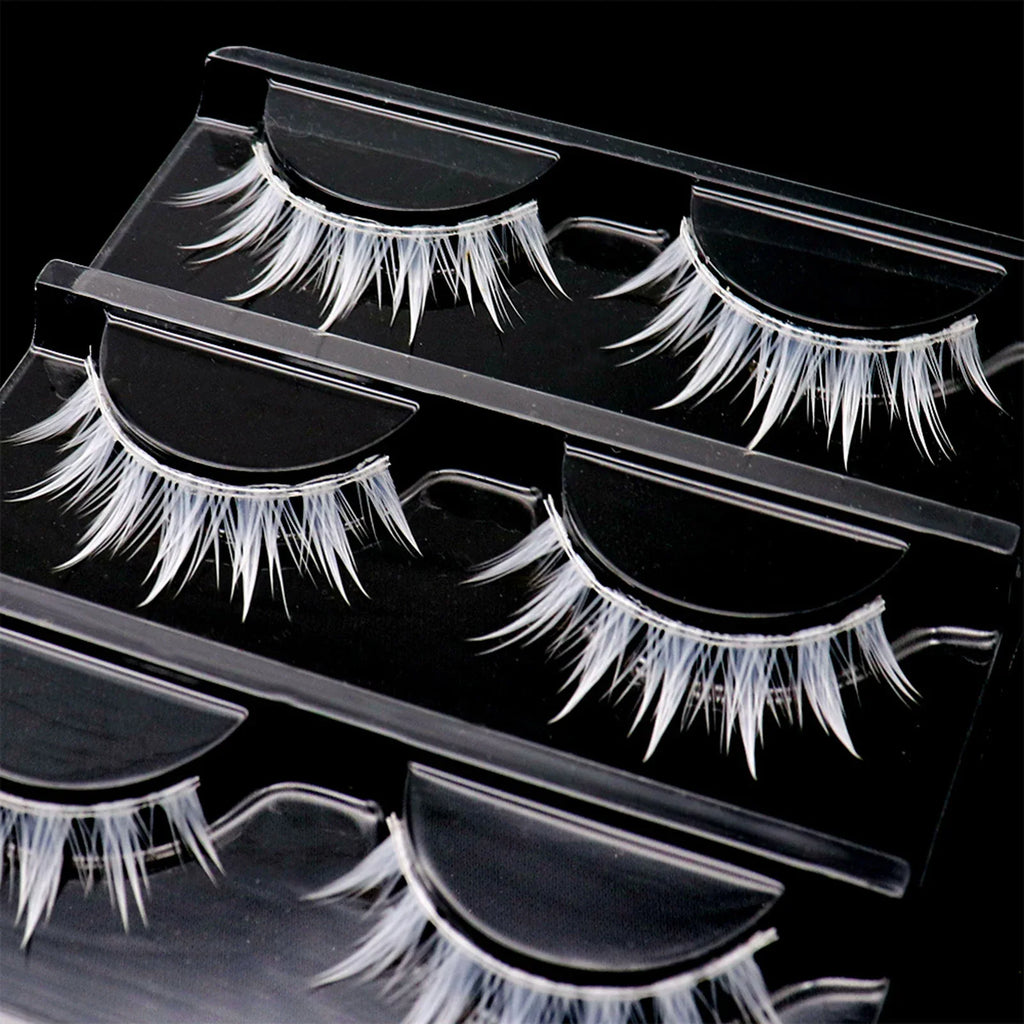 Three pairs of white cosplay false eyelashes in a clear plastic organizer tray