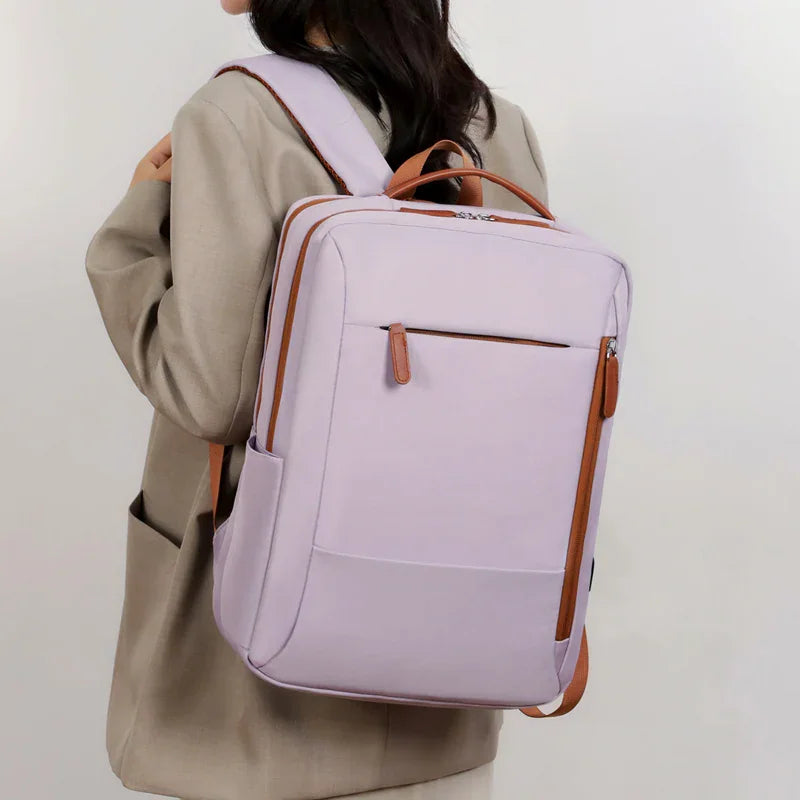 A person wearing a light purple laptop backpack with brown accents.