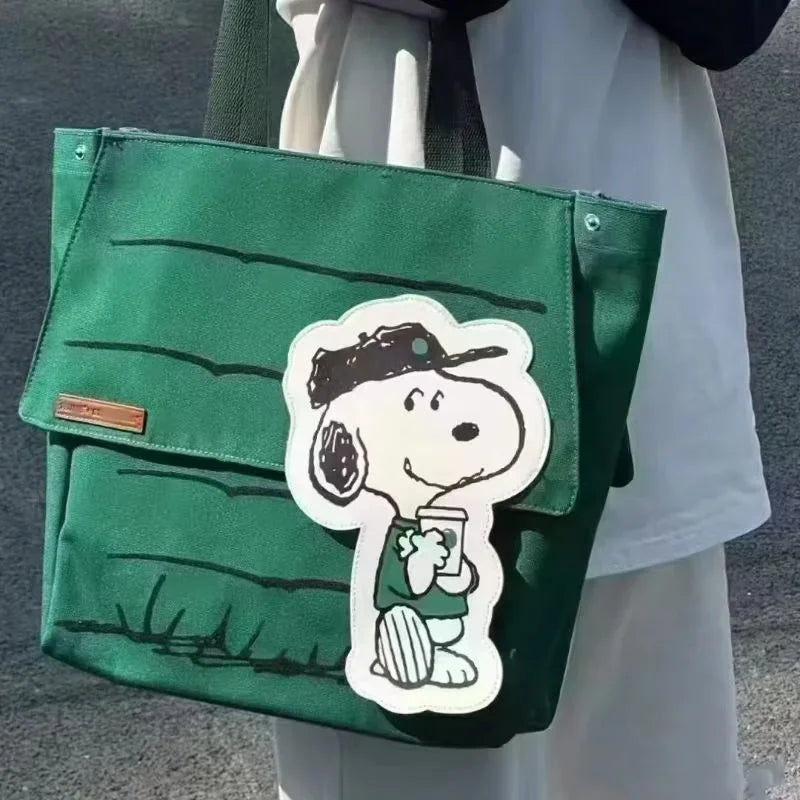 Close up of a person holding a green canvas tote bag with a cartoon dog patch