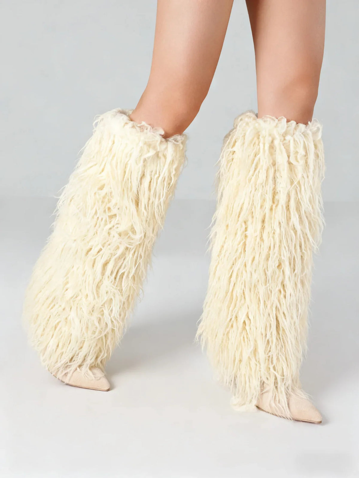 White faux fur knee high stiletto boots with a pointed toe