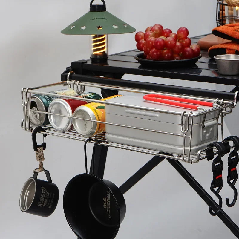 Metal wire storage basket attached to camping table holding food and drinks with hanging cups