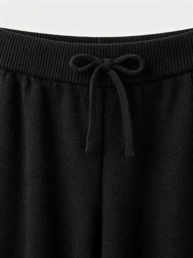 Close-up of the waistband and drawstring of black knit wide leg trousers