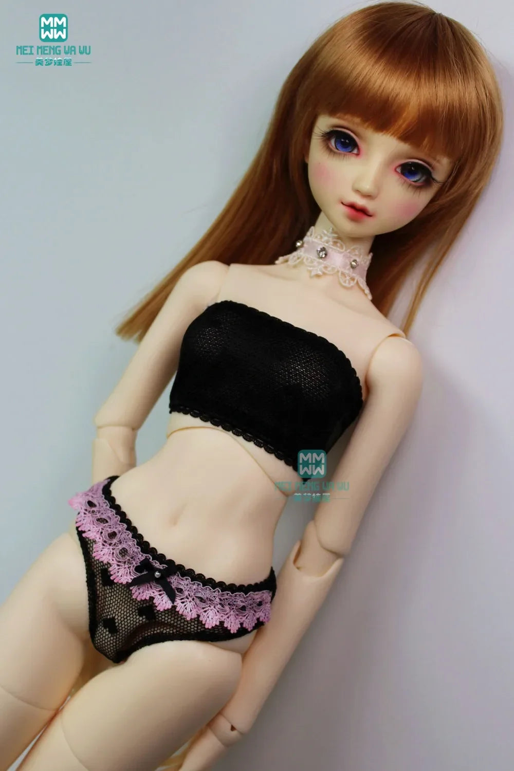 A BJD doll wearing a black lace tube top and black and pink lace briefs