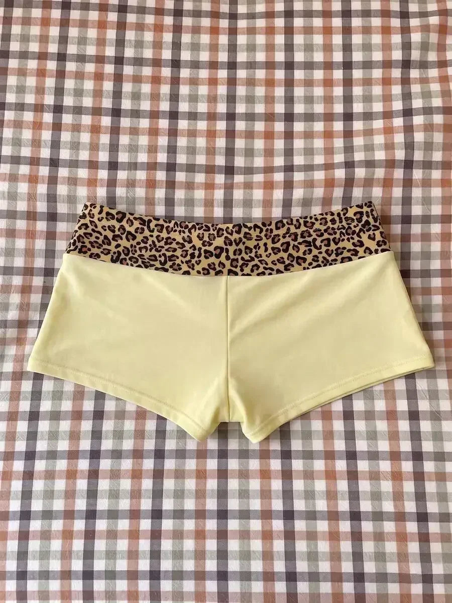 High waisted bikini bottoms featuring a leopard print waistband and pale yellow lower section with drawstring detail