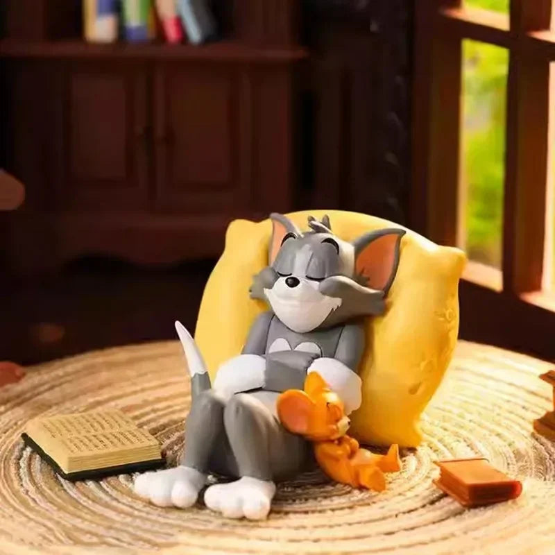 Small cartoon cat and mouse figure resting on a yellow pillow