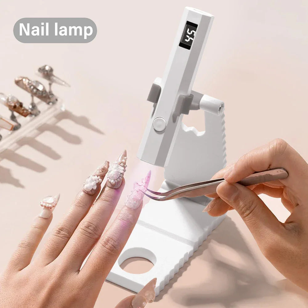 Portable LED UV nail lamp being used to cure gel nails with tweezers