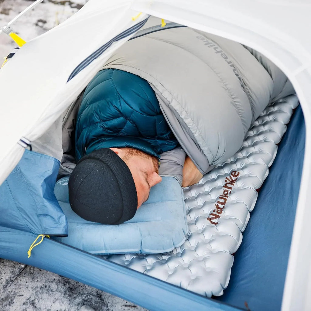 Person sleeping in a tent on an inflatable pad