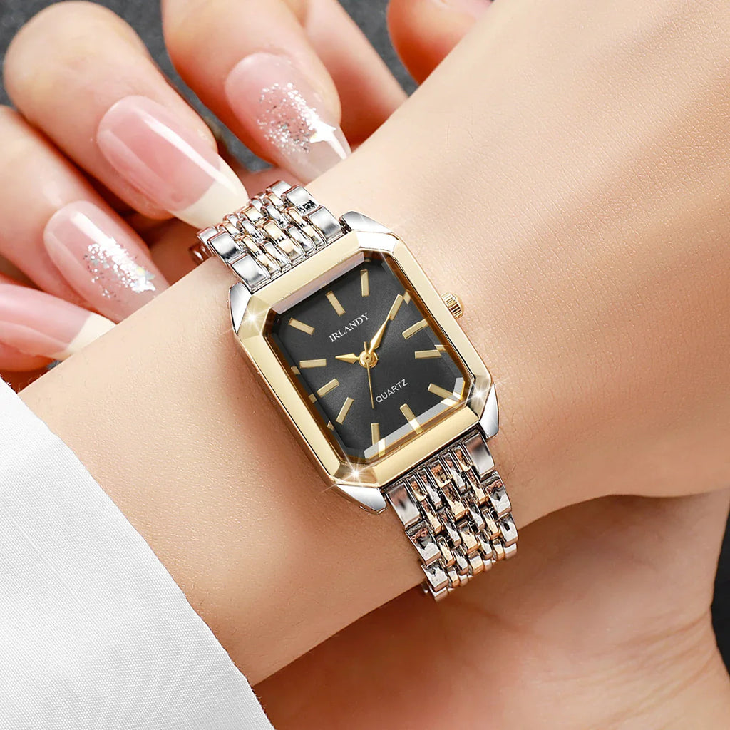 Two-tone rectangular women's quartz watch with a black dial worn on a wrist