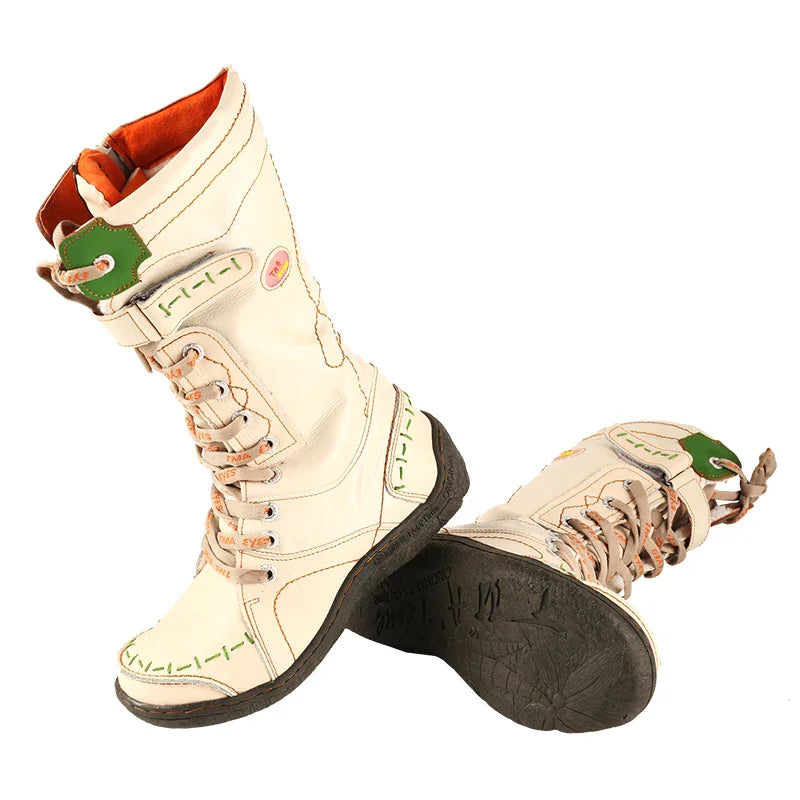 Two beige mid-calf boots with green accents and orange lining on a white background