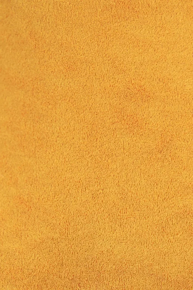 Close-up texture of mustard yellow velvet fabric.