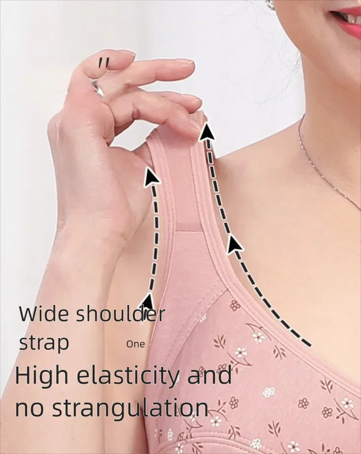 A person demonstrating the wide shoulder strap and elasticity of a pink floral bra