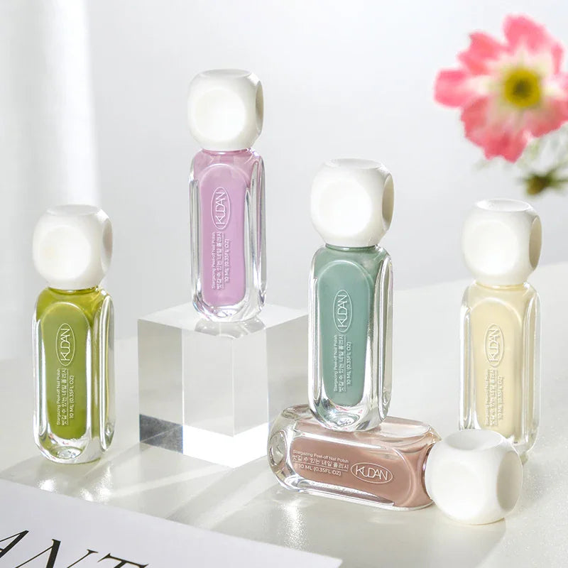 Multiple colorful bottles of peel-off nail polish arranged on a surface.