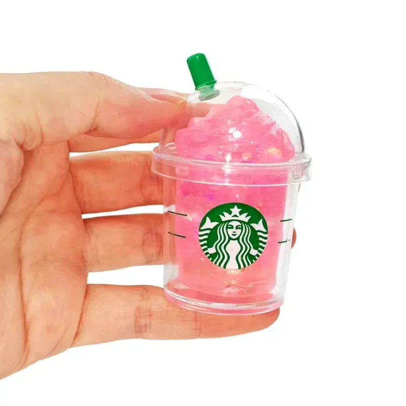 Hand holding a small, pink, glittery iced coffee cup shaped squishy fidget toy.