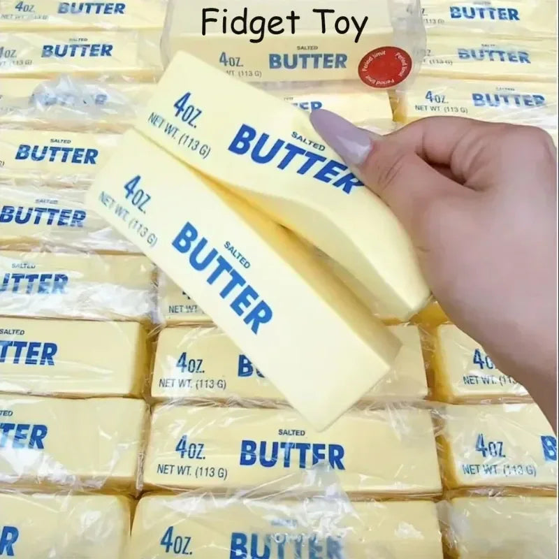 Squishy yellow butter stick fidget toy held in hand with many others in background