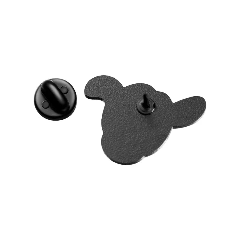 The back side of a cartoon hand gesture enamel pin showing the metal clutch and pin mechanism