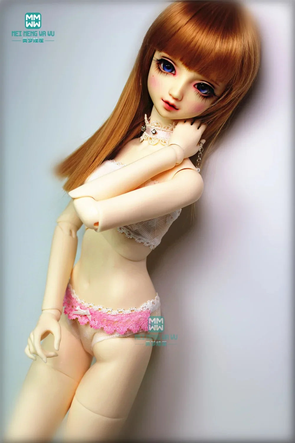 A BJD doll wearing a white lace tube top and pink lace briefs