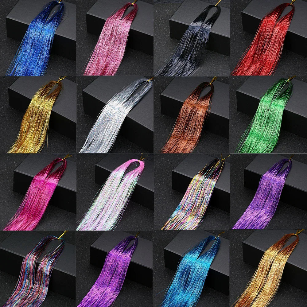 A selection of different colored hair tinsel bundles arranged in a grid on a black surface.