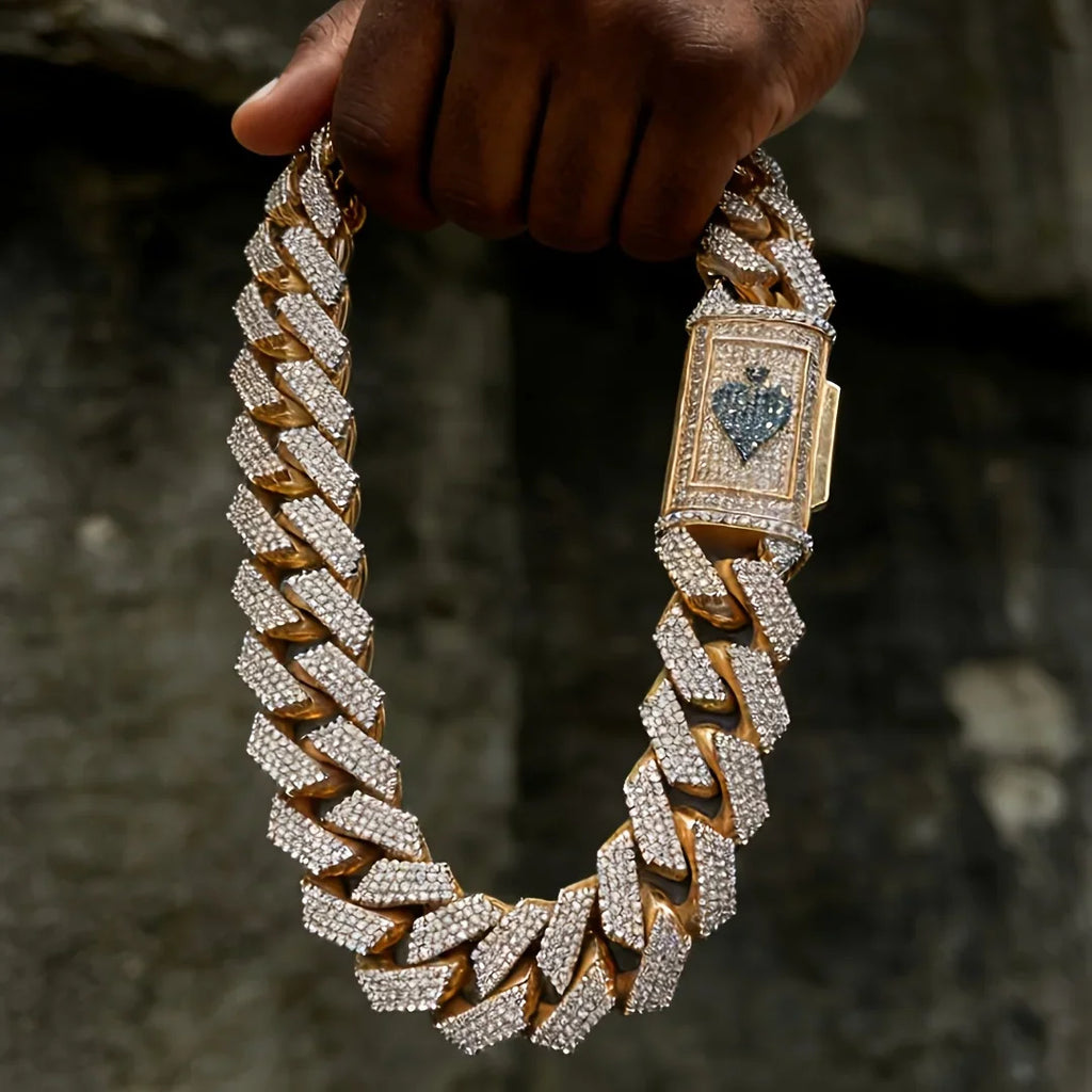 Hand holding rose gold cuban link chain with spade emblem clasp
