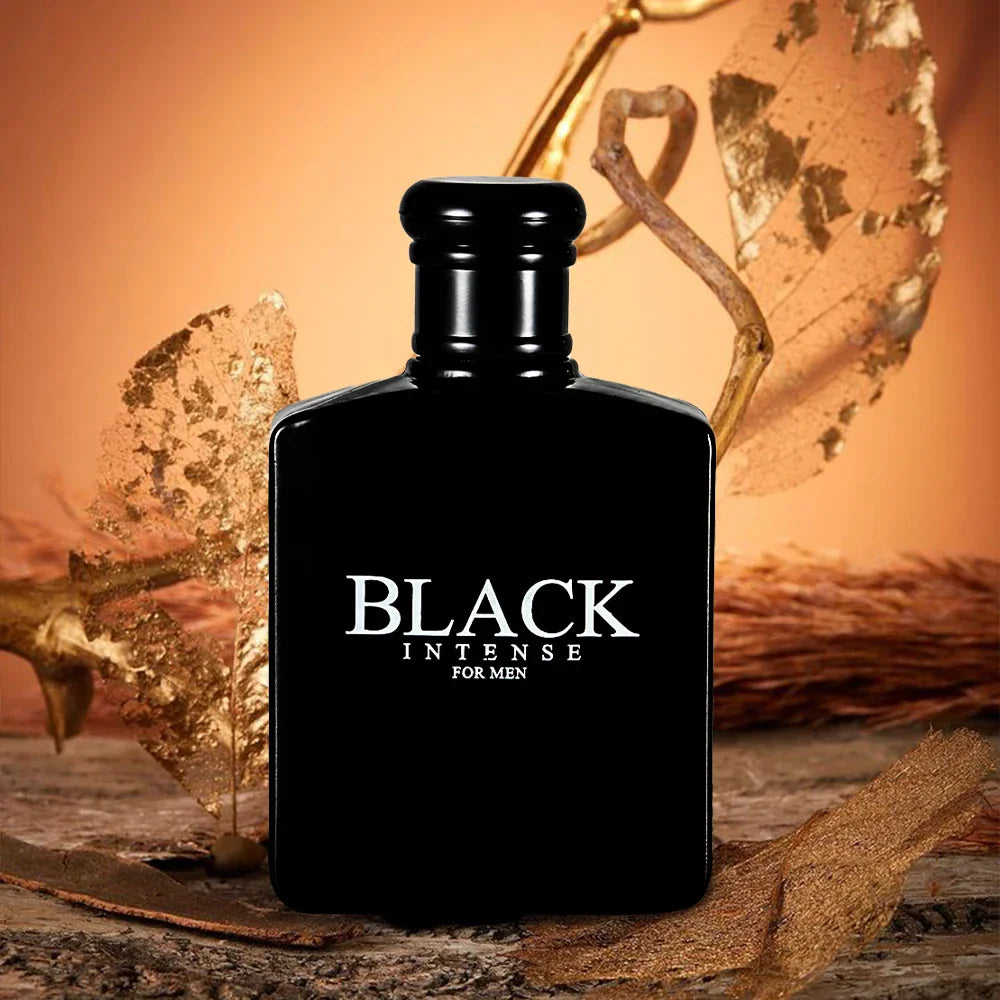 Black perfume bottle for men with gold-toned decorative leaves on a rustic surface