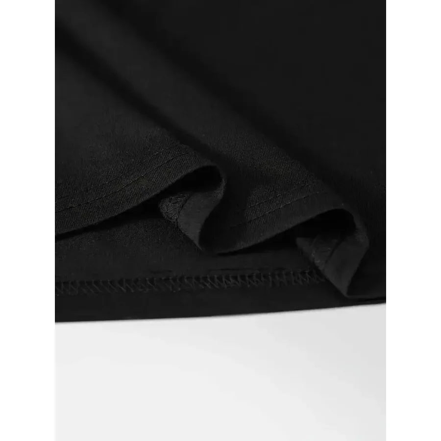 Close-up of the fabric texture and hem of a black t-shirt.