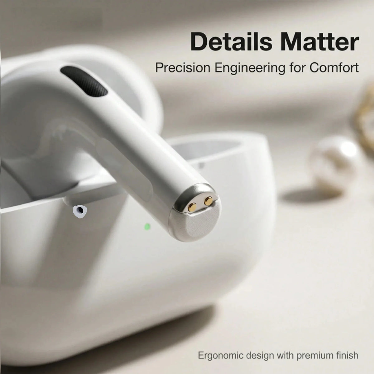 Close-up of white wireless earbud with gold charging contacts