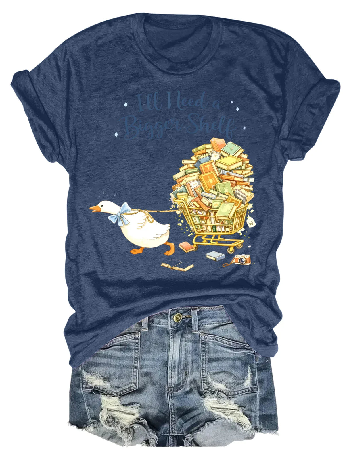 Navy blue short-sleeved t-shirt with a duck pulling a book cart graphic print, styled with denim shorts