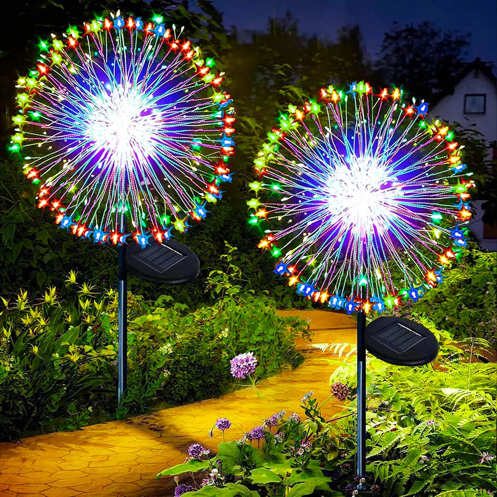 Colorful solar firework garden lights shaped like dandelions installed in a backyard lawn at night