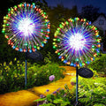 Colorful solar firework garden lights shaped like dandelions installed in a backyard lawn at night
