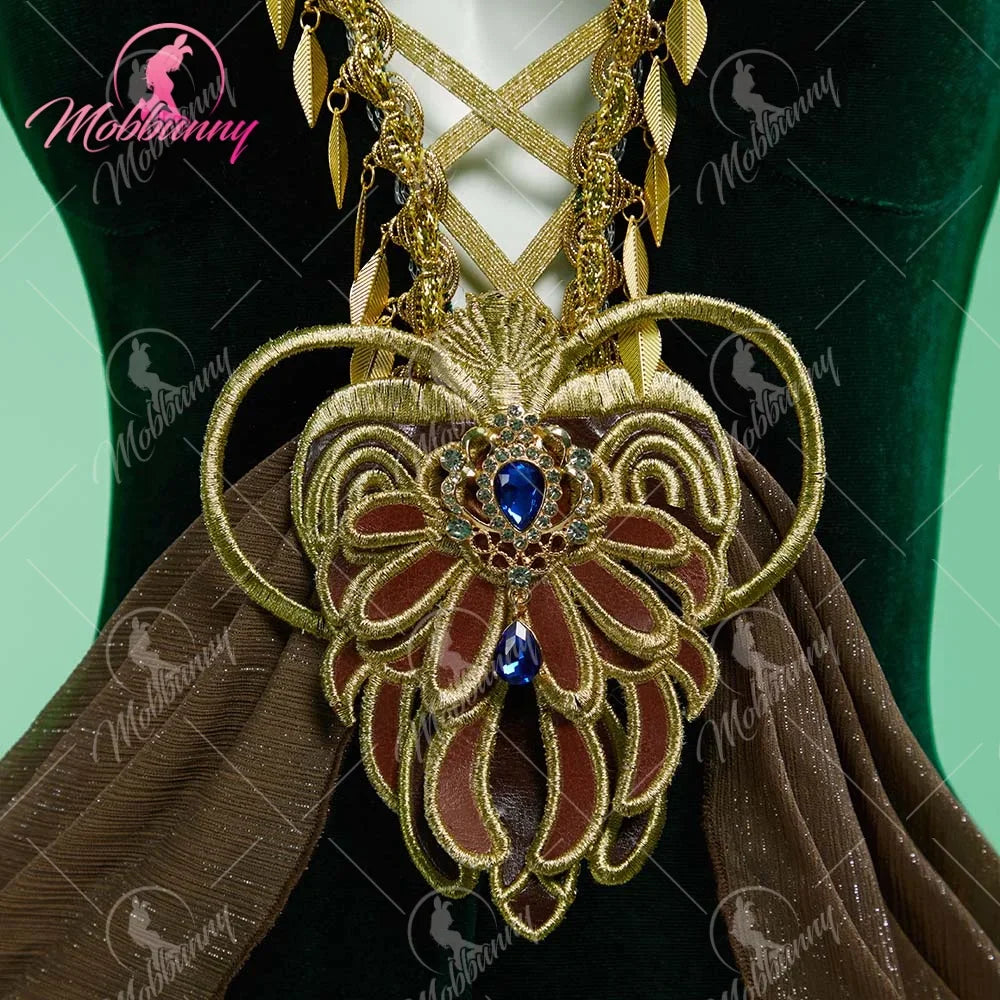 Close up of decorative golden pendant with blue gems on a green velvet bodysuit