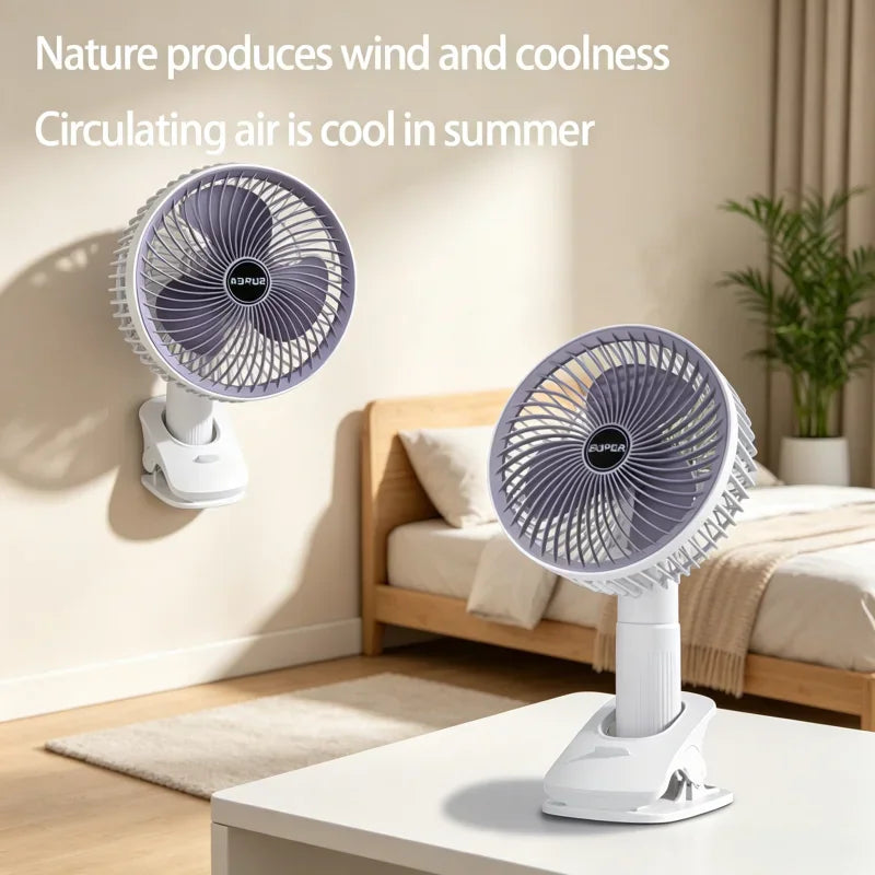 Small portable white desk fan with purple blades and a sturdy clamp base in a bedroom setting