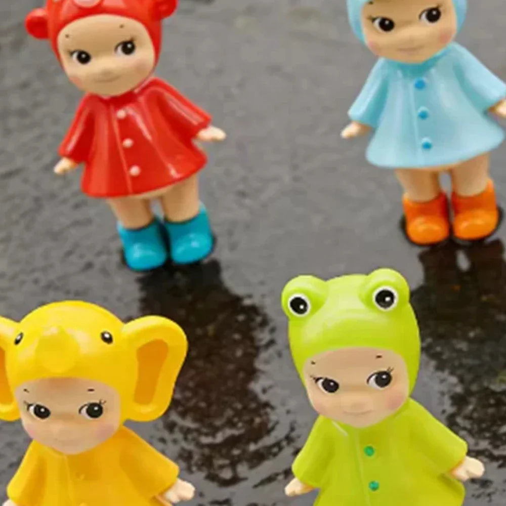 Collection of four small collectible doll figurines in various colorful animal hats and raincoats