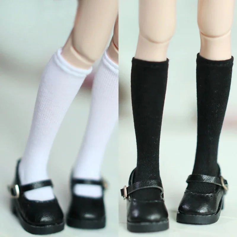 Pair of plain white and black knee-high socks for 1/6 scale dolls worn with black shoes