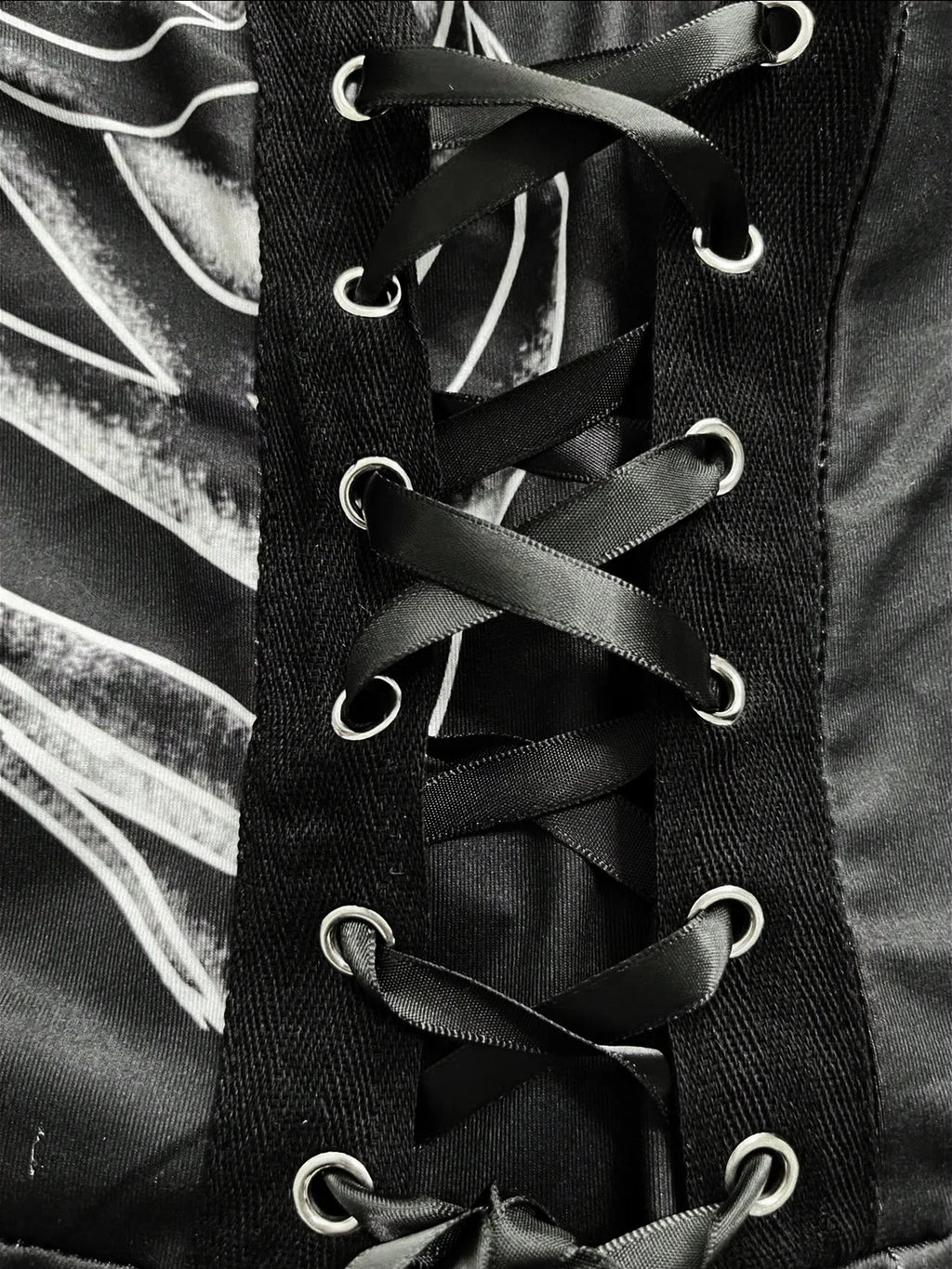 Close-up of black ribbon corset-style lacing with metal eyelets on a dark dress