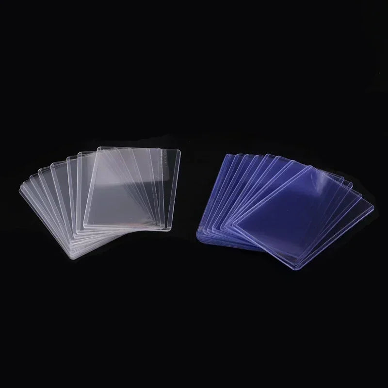 Two groups of clear protective plastic card sleeves stacked on a black background