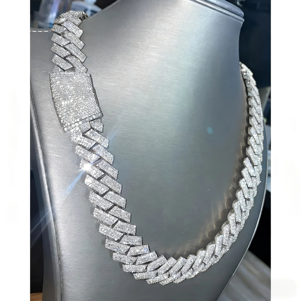 Silver-tone Cuban link chain necklace fully iced out with white stones on a grey display stand.