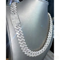 Silver-tone Cuban link chain necklace fully iced out with white stones on a grey display stand.