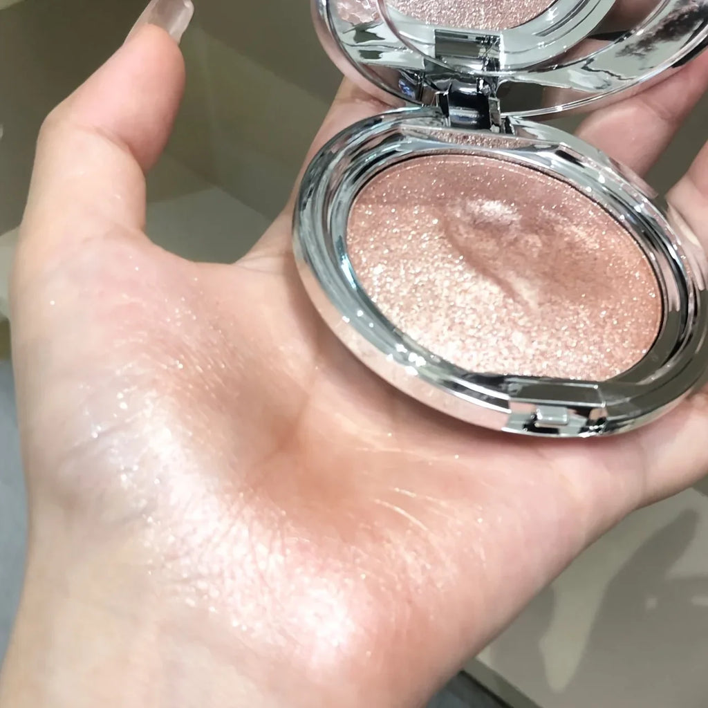 Champagne shimmer highlighter cream swatched on a person's palm