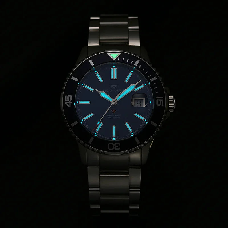 Stainless steel automatic diver watch with glowing hands and markers in the dark