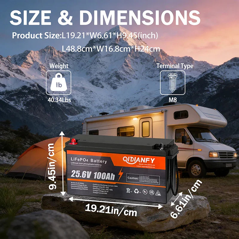 25.6V 100Ah lithium battery showing dimensions in inches and centimeters against a camper and mountain backdrop