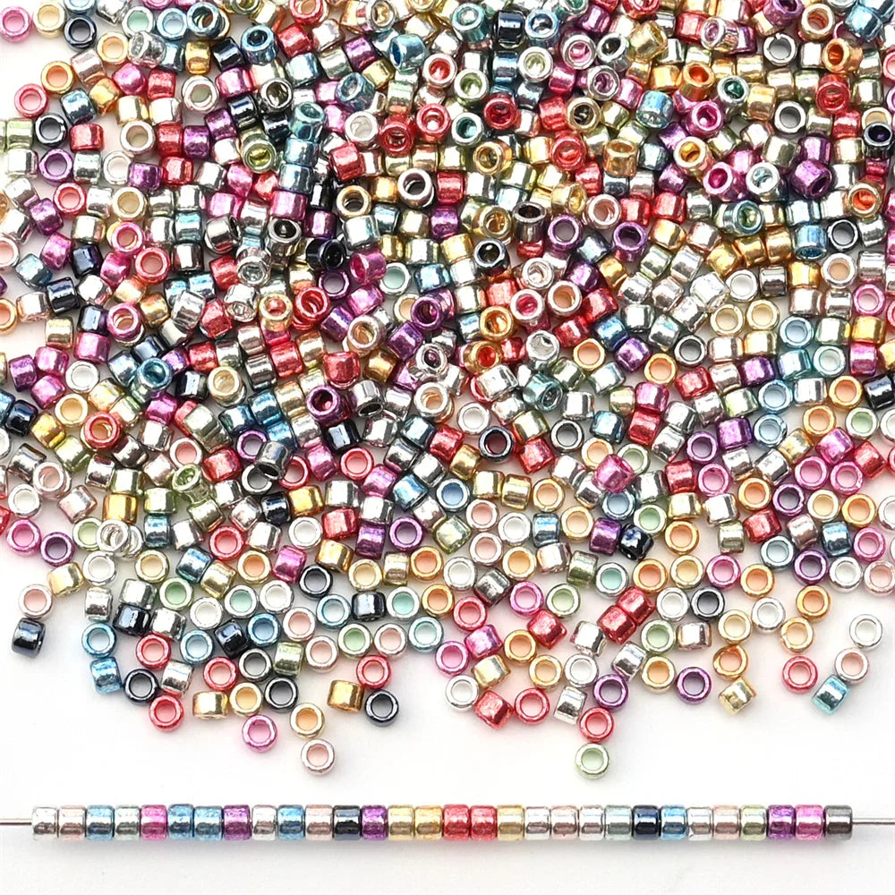 A large pile of assorted colorful metallic glass seed beads with a single row of beads at the bottom.