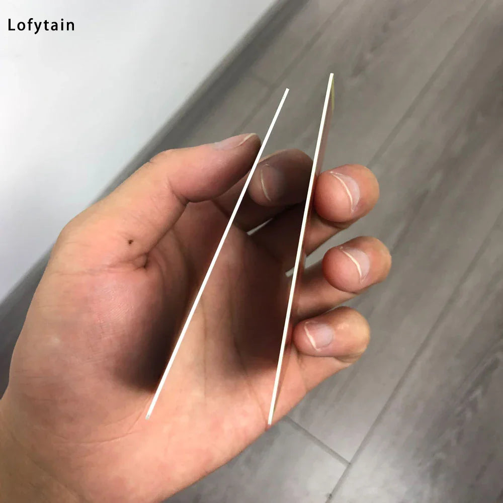 Side profile view of two thin plastic cosplay license cards held by fingers